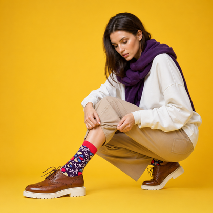 Woman wearing colorful designer crew socks with brown shoes on a yellow background